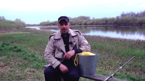 Country man avec canne à pêche et seau va à la pêche, en plein air — Video