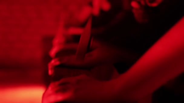 Sok ember ütközik egy fa blokk kalapáccsal egy sötét vörös szobában ijesztő környezetben. Pszichiátriai mániákus koncepció, tiltakozás, közelkép — Stock videók