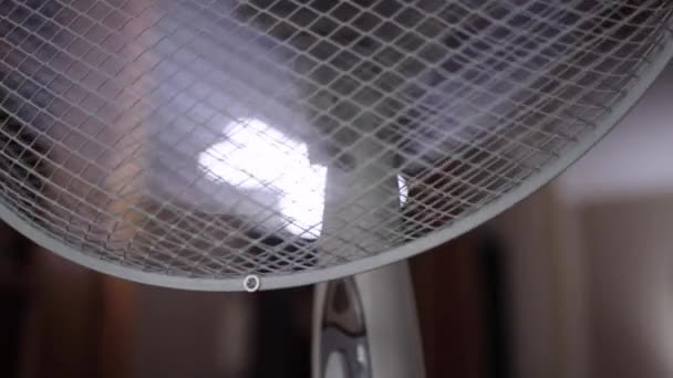 Un ventilateur électrique dans lequel les lames tournent pour créer du vent et refroidir la pièce, gros plan — Video