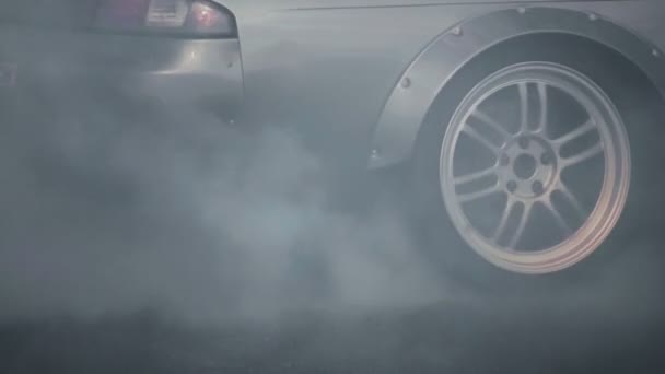 Auto sjíždí po asfaltové cestě během představení. Kouř zpod točícího se kola. Pálení pneumatik. Závodní soutěže ve zpomaleném filmu. Motorsport šampionát. Vysoká rychlost. Detailní záběr. Profesionální extrémní disk — Stock video