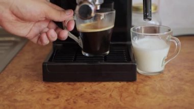 Sütlü sütü sade kahveye dökmek. Manuel kapuçino makinesiyle kapuçino yapıyorum, yakın plan.