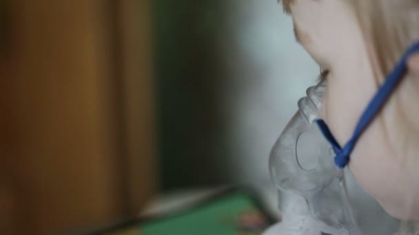 Маленькая девочка дышит лекарством от туманности, когда кашляет. Лечение легких детей с ингаляцией, крупным планом — стоковое видео