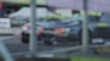 Gösteri sırasında iki araba asfalt yolda keskin bir dönüş yaparak sürükleniyor. Lastik patlamış. Ağır çekimde yarış yarışmaları. Motorsport şampiyonası. Yüksek hız. Bulanık. Profesyonel aşırılık güdüsü