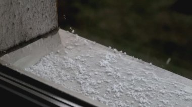 Pencere pervazına yoğun dolu vuruyor, bu doğal bir olay. Kötü hava, yakın çekim.