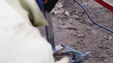Kaynak makinesi kullanan bir kaynakçı inşaat ve endüstri sırasında metal bir yapı kaynatıyor.
