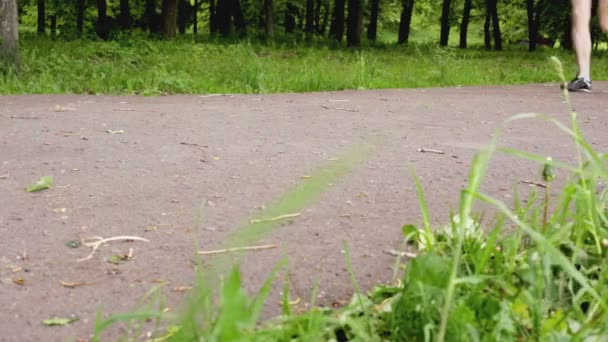 Ben av människor som springer på ett löpband i parken, närbild. Idrott och löpning, sommar — Stockvideo