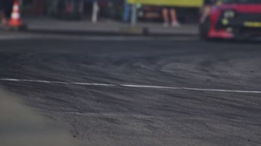 Araba gösteri sırasında asfalt yolda keskin bir virajda sürükleniyor. Lastik patlamış. Ağır çekimde yarış yarışmaları. Motorsport şampiyonası. Yüksek hız. Profesyonel aşırılık güdüsü