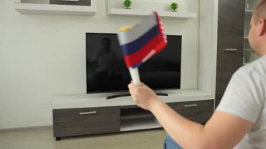 Spor fanatiği evde TV karşısında oturur. Rusya ABD 'ye karşı. Kökler ulusal bayrak sallıyor ve Yaz Kış Oyunları 'nın yayınını izliyor. Dünya şampiyonası kupası.