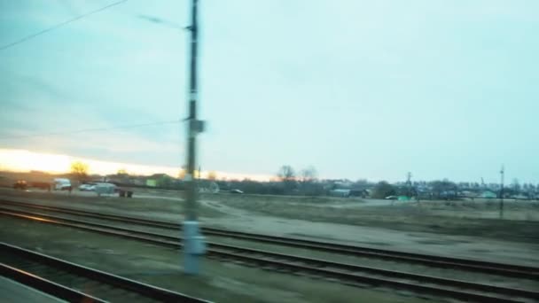 Tren yolunda araba sürerken tren penceresinden ve gökyüzünde güneşli bir günbatımı, arka plan. Ulaşım — Stok video