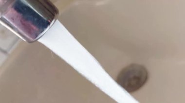 Musluktan akan su lavaboya akıyor. Su tüketimi, kanalizasyon ve su tesisatı kavramı