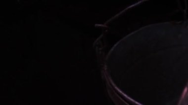 Köylü genç beyaz adam suyla dolu bir kuyuya bakıyor..