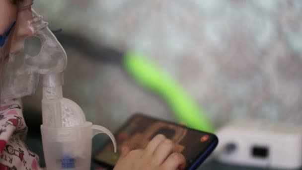 Ein kleines Mädchen atmet Medikamente aus einem Vernebler, wenn es hustet. Behandlung der Kinderlunge durch Inhalation, Nahaufnahme — Stockvideo