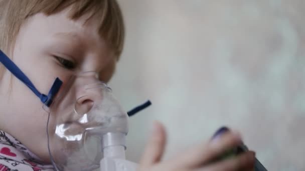 Seorang gadis kecil bernapas obat dari nebulizer ketika dia batuk. Pengobatan paru-paru cabai dengan inhalasi, close-up — Stok Video