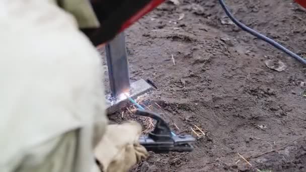 En arbetssvetsare som använder en svetsmaskin svetsar en metallstruktur under byggnation, industri — Stockvideo