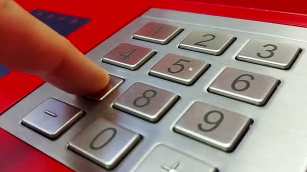 A person enters a pin code at an ATM. Finger presses ATM digit buttons. Concept of security and protection of money on the card, close-up — Stockvideo