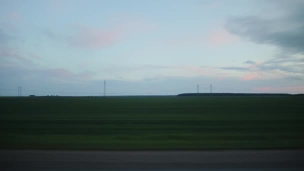 Beautiful evening sky and a field with grass, great landscapes of nature. View of the trip from the car window. Copy space for text, outdoor — Stock Video
