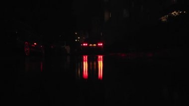Fall. The car during the rain at night stands at the entrance of the house in the yard waiting for a passenger. Reflection in a puddle from the rear red headlights. Autumn. Low angle shot