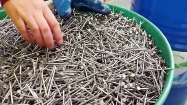 Man chooses nails for construction in a store, close-up