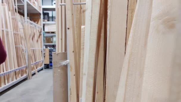 Een man kiest voor houten bouwmaterialen in een hypermarkt, industriële — Stockvideo