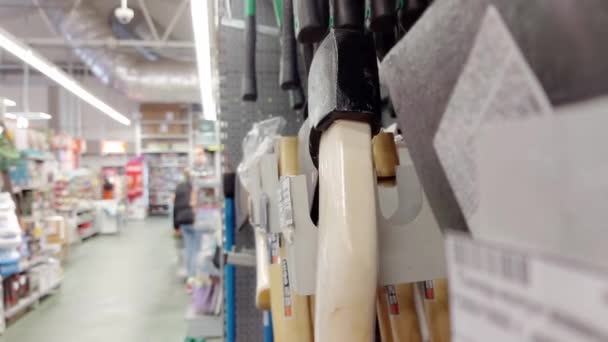 A man chooses an ax in a building materials store, close-up — Stok video