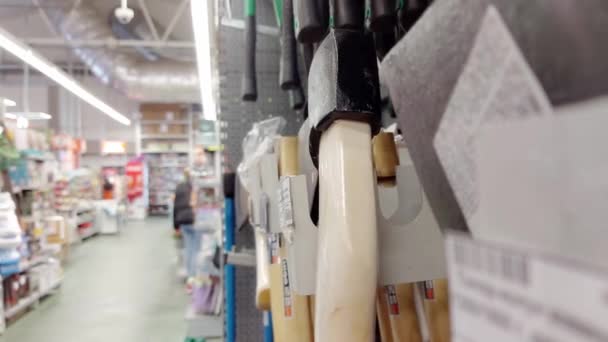 A man chooses an ax in a building materials store, close-up — Stock Video