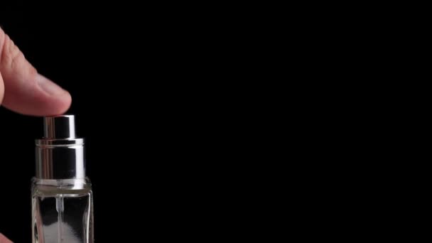 Manshanden trycker på parfymdiffusorn på en svart bakgrund. Kopiera utrymme för text, närbild, arom — Stockvideo