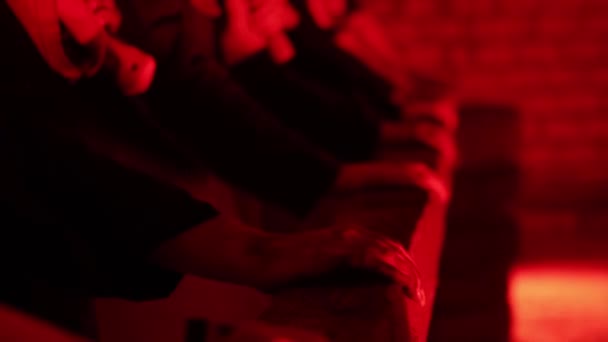 Sok ember ütközik egy fa blokk kalapáccsal egy sötét vörös szobában ijesztő környezetben. Pszichiátriai mániákus koncepció, tiltakozás, közelkép — Stock videók