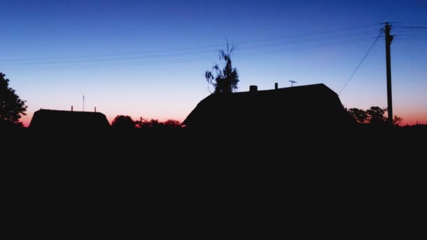 Pagi yang indah matahari terbit di sebuah desa di alam, rumah desa. Langit biru dengan sinar pertama matahari, latar belakang, salinan ruang untuk teks — Stok Video