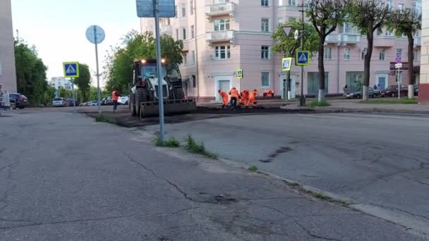 SMOLENSK, RUSSIA 26.05.21：修路、填路和铺设新沥青的道路工人 — 图库视频影像