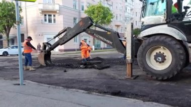 SMOLENSK, RUSSIA 26.05.21: Yolu tamir eden, yoldaki boşlukları dolduran ve yeni asfalt döşeyen yol işçileri