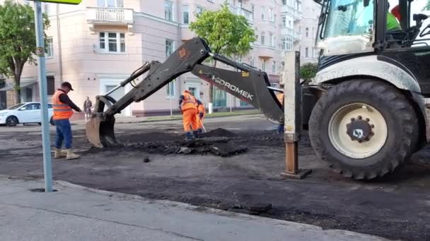 SMOLENSK, RUSSLAND 26.05.21: Straßenarbeiter reparieren die Straße, füllen Löcher in der Straße und verlegen neuen Asphalt — Stockvideo