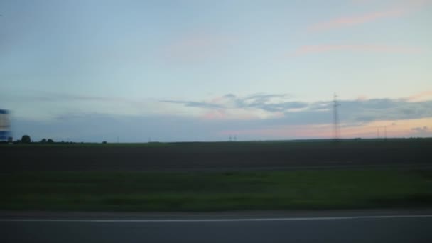 Beautiful evening sky and a field with grass, great landscapes of nature. View of the trip from the car window. Copy space for text, outdoor — Stock Video
