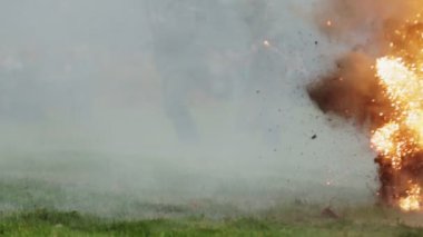 Battle reconstruction of invasion to USSR 22 June 1941 at World War 2 between German and Soviet soldiers. Smoke from grenade explosion. Men in Wehrmacht uniform walk with guns. Battle
