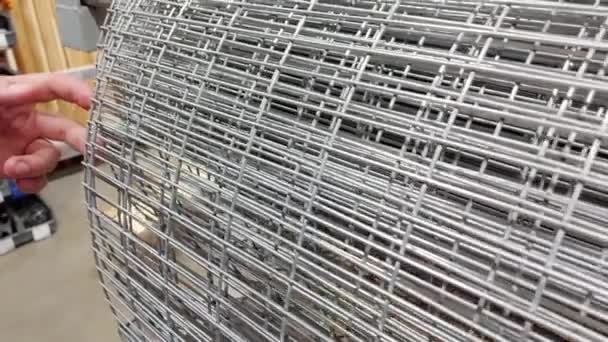 A man chooses a metal reinforcing mesh in a building materials store, close-up — Video