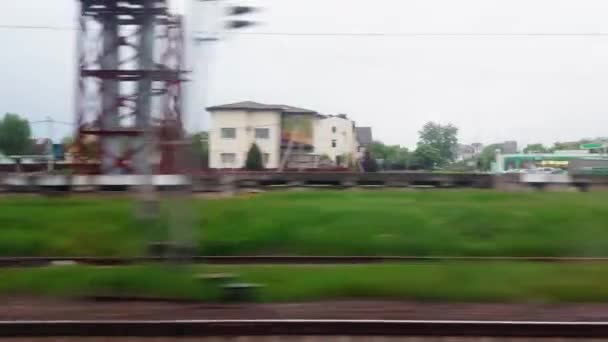 Uitzicht vanuit het treinraam naar het dorp en de spoorbrug. Achtergrond buiten het raam, spoorweg — Stockvideo