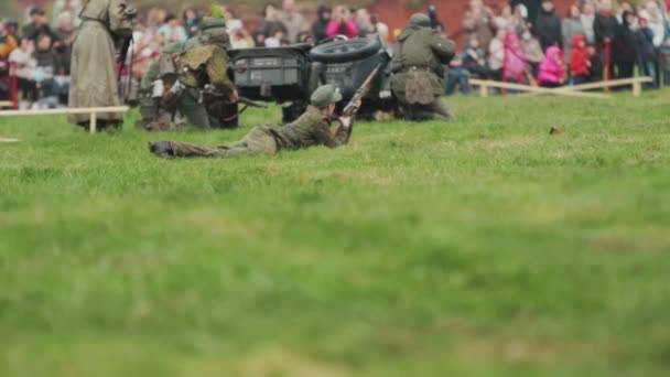 Soldiers in German army uniform stand, lie and shoot fire at Soviet soldiers during battle reconstruction of invasion to USSR 22 June 1941 at World War 2. BOBRUISK, BELARUS - MAY 9, 2021 — Vídeo de Stock