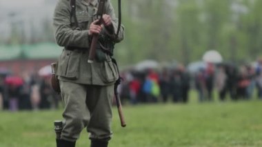 2. Dünya Savaşı sırasında Alman ordusunun Wehrmacht üniformalı sakallı askeri, 22 Haziran 1941 'de Sovyetler Birliği' nde işgalin yeniden inşası sırasında elinde tüfekle koşuyordu. Yağmur yağar