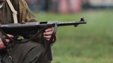 2. Dünya Savaşı sırasında Alman ordusunun Wehrmacht üniformalı askeri, 22 Haziran 1941 'de Sovyetler Birliği' nde SSCB 'nin yeniden inşası sırasında çarpışmayı beklerken maschinenpistole tabancasıyla oturuyor. Yavaş çekim