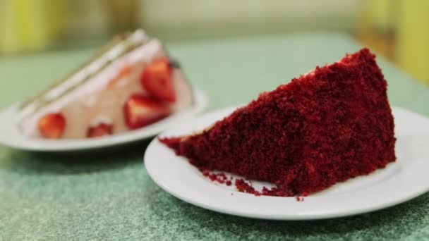 Dos pedazos de pastel con fresas frescas y crema batida en una mesa en un café. Dulce y delicioso postre, primer plano — Vídeos de Stock
