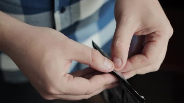 En man öppnar ett paket med ett bantande, fettförbrännande plåster. Närbild, metabolism — Stockvideo