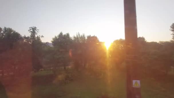 View from the train window. Sunrise on the background of a beautiful forest and railway. Copy space for text, summer — Stock Video