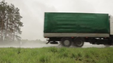 Perde arkası bir kamyon karayolunda yağmurlu havada kargo taşır. Kötü yol görüş konsepti. Uzayı metin için kopyala. Yavaş çekim