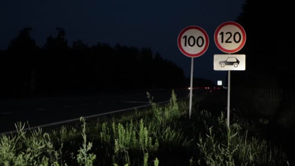 Vägmärken med hastighetsbegränsning på natten på motorvägen. Bilar kör på vägen med strålkastare på, trafiksäkerhet. Kopiera utrymme för text — Stockvideo