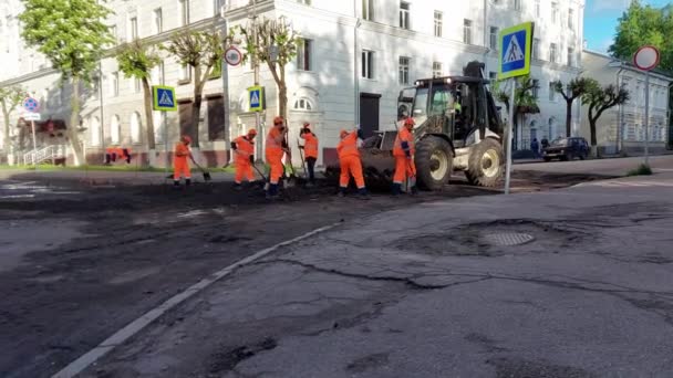 SMOLENSK, RUSKO 26.05.21: Silniční dělníci opravují silnici, vyplňují díry v silnici a pokládají nový asfalt — Stock video