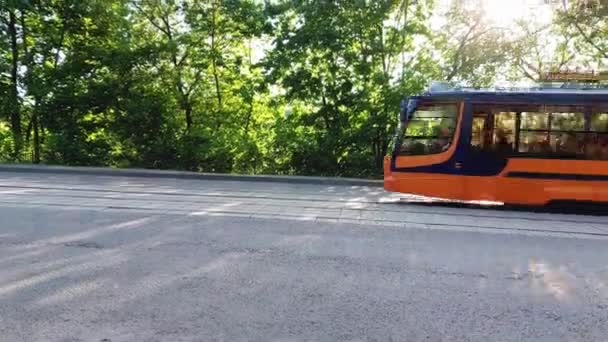 Tram rijdt in de stad tegen de achtergrond van groene bomen in de zomer, close-up — Stockvideo