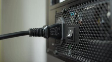 Sistem ünitesindeki bir düğmeyle güç kaynağını kapatıp elektrik kablosunu çıkarıyorum. Yakın plan. Bilgisayarı kapat.