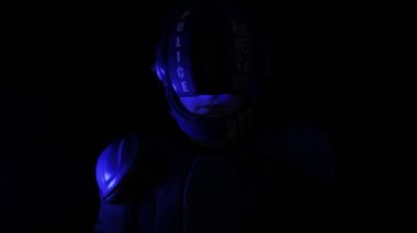 Siberpunk gelecek konsepti. Karanlıktaki biyonik sayborg polis memurunun portresi. Halfman robotu kameraya bakıyor. Gelecekçi bilim kurgu sahnesi, bilim kurgu. Kırmızı mavi ışık yanıp sönüyor. Hukuk ve Düzen kavramı.