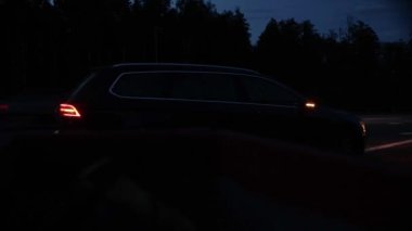 Tehlikeli uyarı ışıklarına sahip bir yolcu vagonu gece yolun kenarında duruyor, bozuluyor.