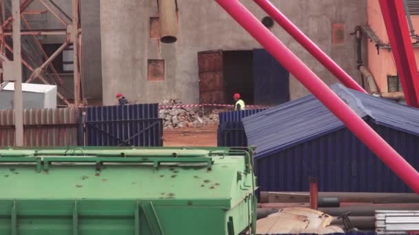 Wiederaufbau und Reparatur im Werk. Arbeiter mit Schutzhelmen inspizieren das Gelände der Fabrik, der Industrie — Stockvideo