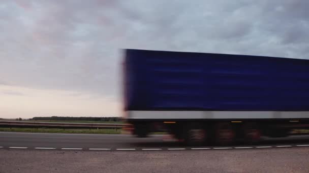 El camión semirremolque conduce por la carretera por la noche con los faros encendidos. Cielo azul. El modo de trabajo y el resto de los conductores de camiones. Copiar espacio para texto, fondo — Vídeo de stock